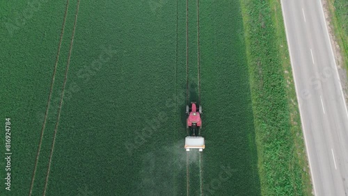 Increasing wheat yields using fertilizers. Tractor spreading agricultural lime in field aerial view