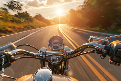 Motorcyclist riding along a scenic road at sunset, embodying freedom and adventure photo