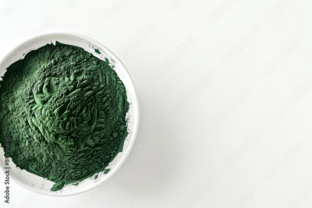 Top view of natural spirulina powder contained in a white ceramic bowl, isolated on a bright white background with copy space Top view of natural spirulina powder contained in a white ceramic bowl, isolated on a bright white background with copy space