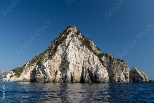 Beautiful view of a triangular rock in the blue sea.