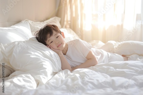 Cute Asian boy waking up on white bed at home in sunny morning