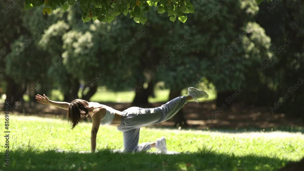 A woman is doing yoga in a park A woman is doing yoga in a park