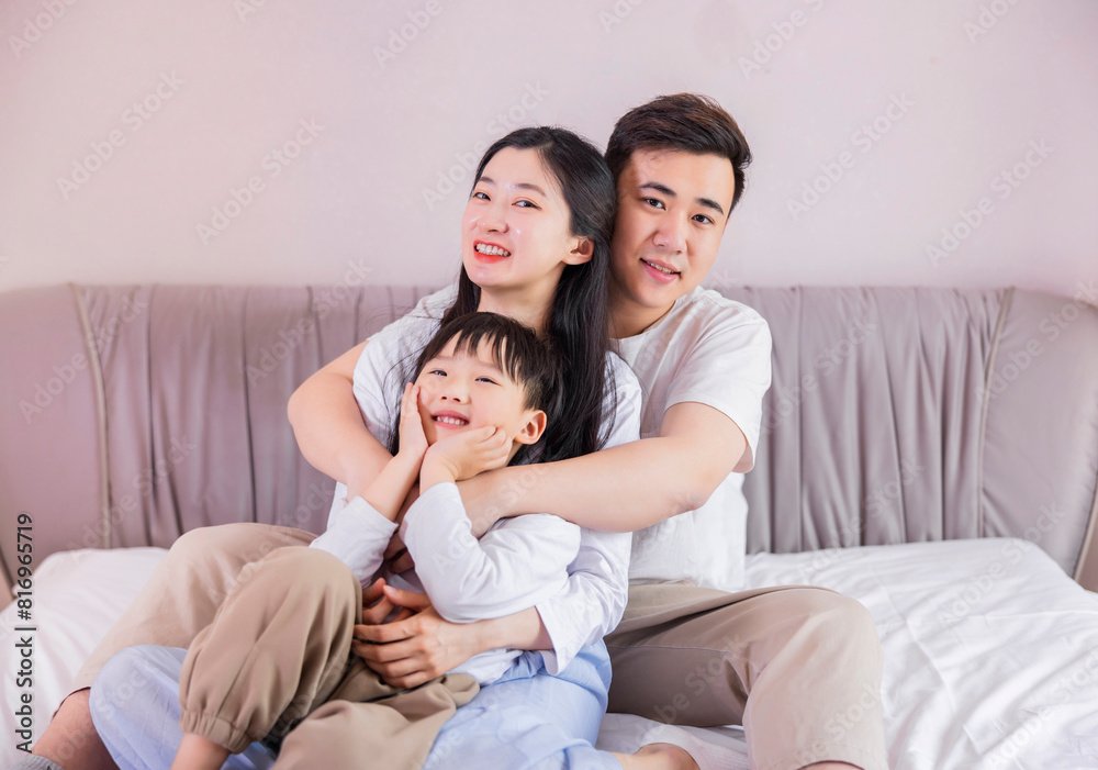 A family of three in the bed in the bedroom A family of three in the bed in the bedroom