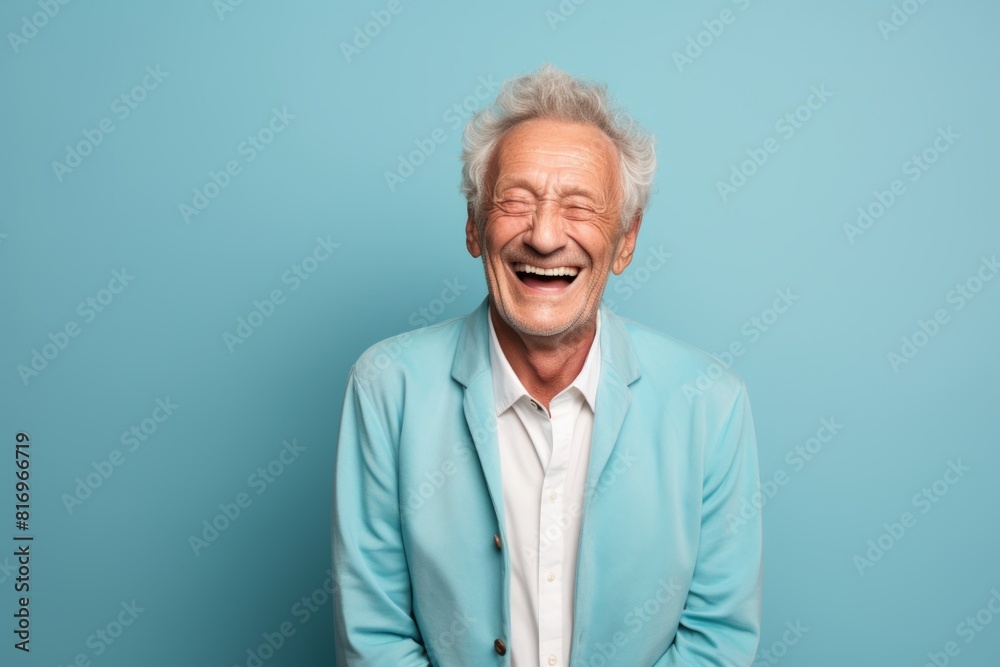 Portrait of a satisfied man in his 80s laughing on soft teal background Portrait of a satisfied man in his 80s laughing on soft teal background