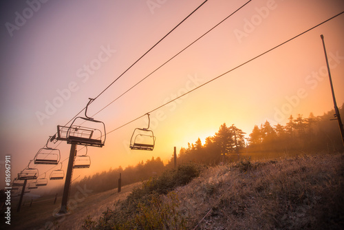 Sunrise in the mountains with a  ski chairlift and foggy air at dawn in Vermont. photo
