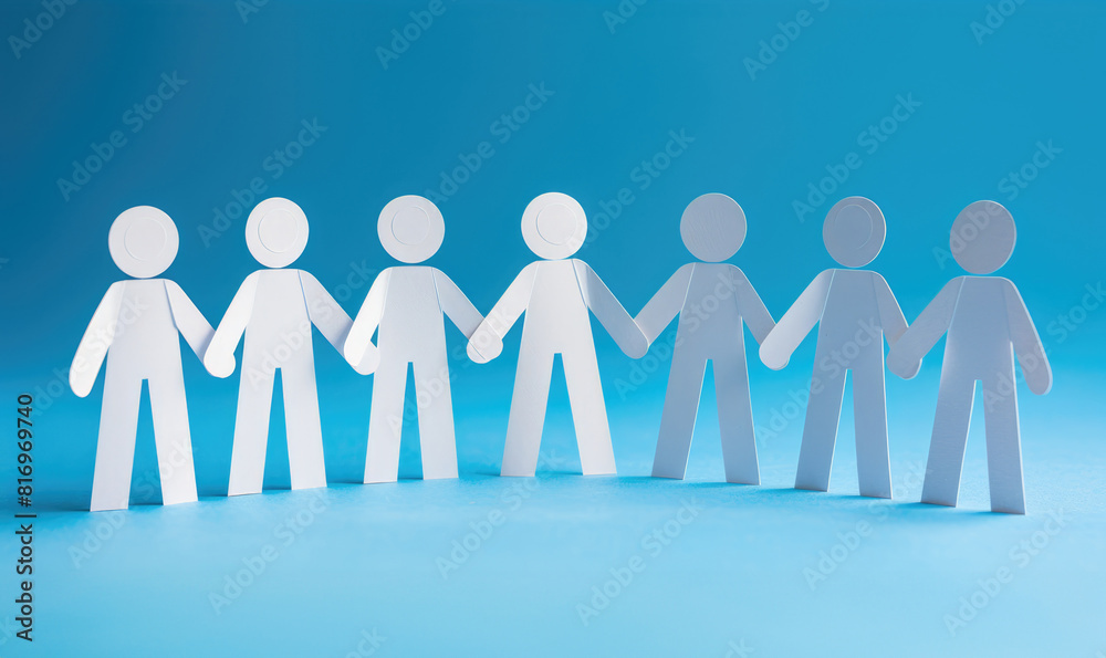 A group of paper people holding hands on a blue background.