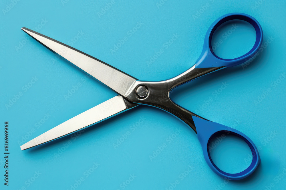 A pair of blue scissors is open against a blue background. A pair of blue scissors is open against a blue background.