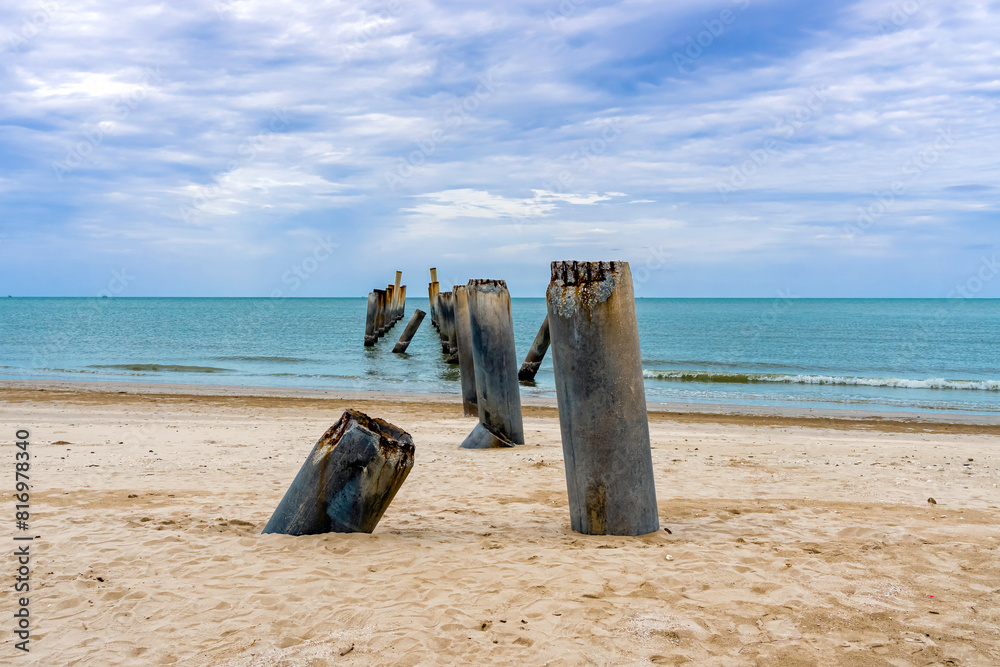 Beautiful view of leaning pillars of the old pier. Slanted concrete pole beach. Abandoned fishing pier pillar by the sea. Many of old concrete pillars were left on beach by the sea. Selective focus. Beautiful view of leaning pillars of the old pier. Slanted concrete pole beach. Abandoned fishing pier pillar by the sea. Many of old concrete pillars were left on beach by the sea. Selective focus.