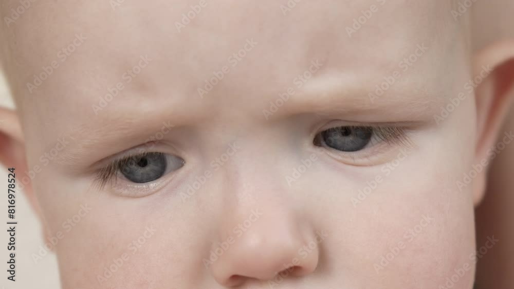 The little boy looks down intently. Sad eyes of a child close-up. Slow motion. The little boy looks down intently. Sad eyes of a child close-up. Slow motion.