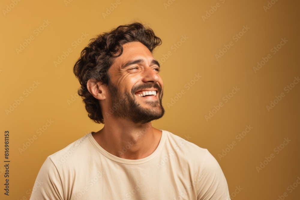 Portrait of a satisfied man in his 30s laughing over soft brown background Portrait of a satisfied man in his 30s laughing over soft brown background