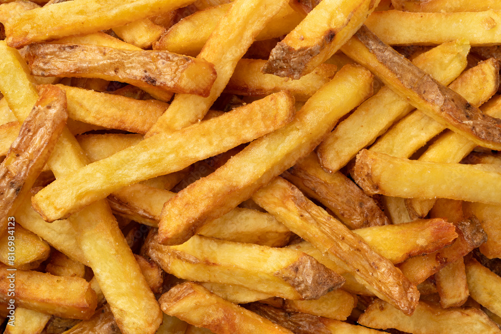 Fresh baked French peel potato fries full frame as background close up Fresh baked French peel potato fries full frame as background close up