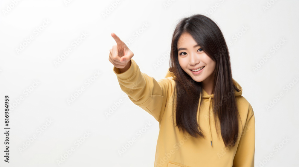 Young Asian woman in yellow hoodie pointing away Young Asian woman in yellow hoodie pointing away