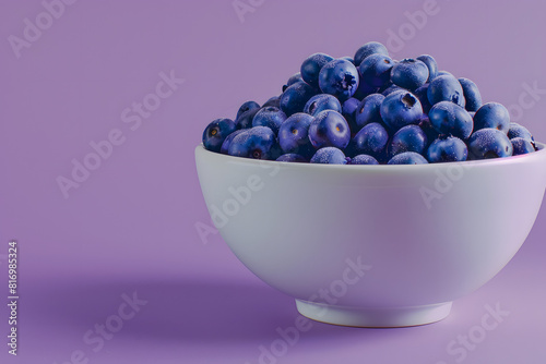 A detailed shot of a bowl of fresh blueberries on a solid purple background