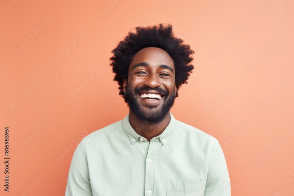 Portrait of a joyful afro-american man in his 30s smiling at the camera while standing against pastel or soft colors background Portrait of a joyful afro-american man in his 30s smiling at the camera while standing against pastel or soft colors background