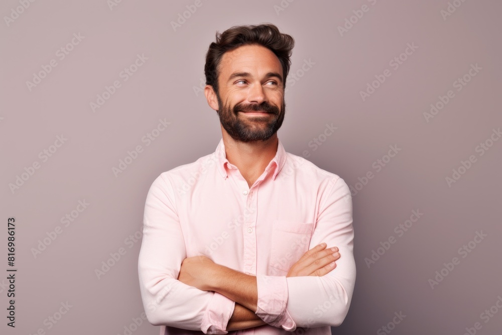 Portrait of a satisfied man in his 30s with arms crossed isolated in pastel or soft colors background Portrait of a satisfied man in his 30s with arms crossed isolated in pastel or soft colors background