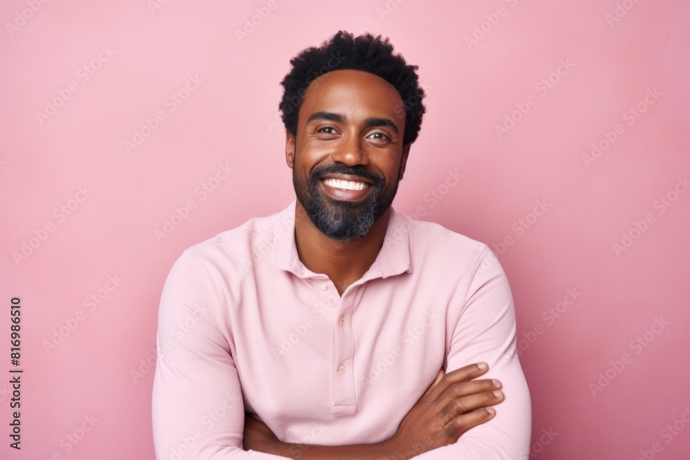 Portrait of a satisfied afro-american man in his 30s with arms crossed while standing against pastel or soft colors background Portrait of a satisfied afro-american man in his 30s with arms crossed while standing against pastel or soft colors background