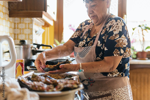 Elderly lady preparing traditional meal in cozy kitchen photo