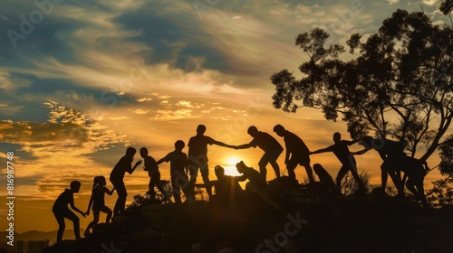 Group of silhouetted people on a hill at sunset  with the sun low on the horizon casting a warm glow