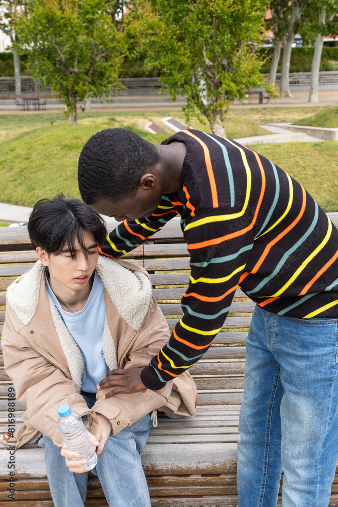 Man assists friend during hypoglycemic episode in park Man assists friend during hypoglycemic episode in park