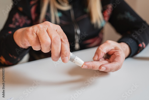 Woman checking blood sugar level with glucose meter photo