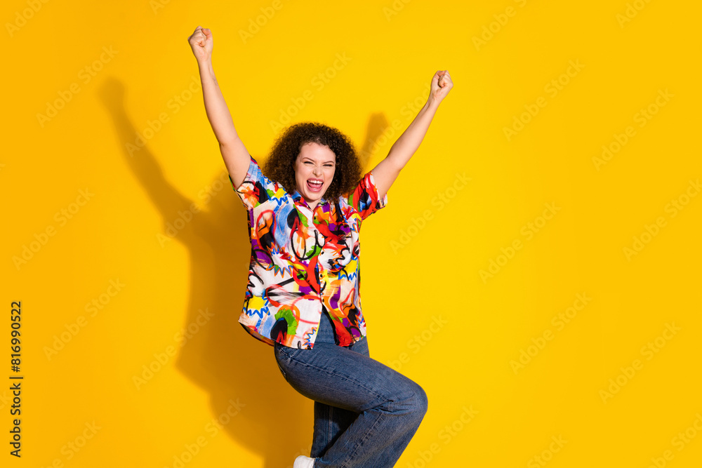 Photo portrait of attractive young woman winning celebrate dressed stylish colorful print clothes isolated on yellow color background Photo portrait of attractive young woman winning celebrate dressed stylish colorful print clothes isolated on yellow color background