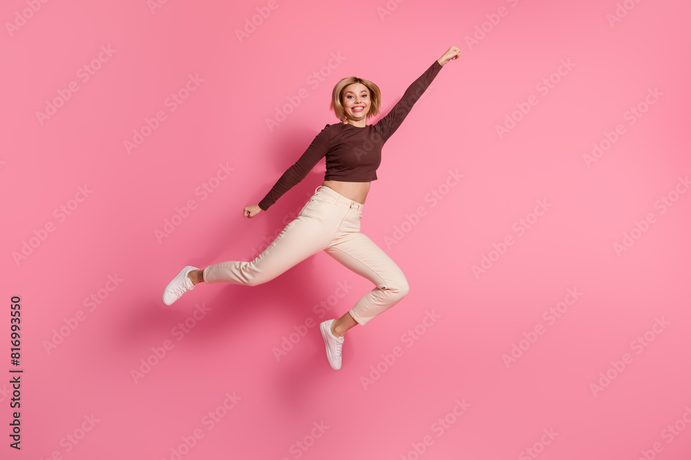 Photo of charming cheerful crazy girl wear trendy brown clothes fly empty space isolated on pink color background