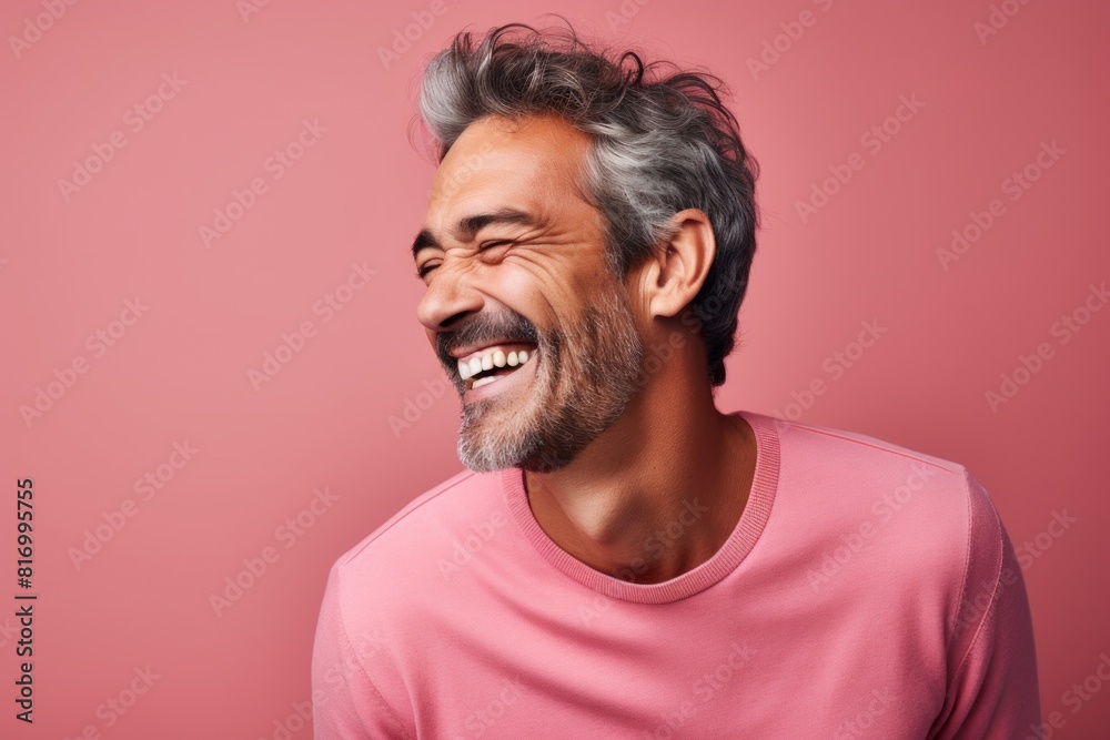 Portrait of a tender man in his 40s laughing isolated in pastel or soft colors background Portrait of a tender man in his 40s laughing isolated in pastel or soft colors background