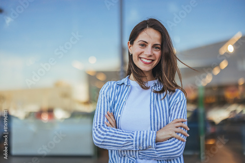 Portrait of happy businesswoman looking at camera. Successful proud woman in city street at sunset. Satisfied latin business woman in formal clothing smiling outdoors.