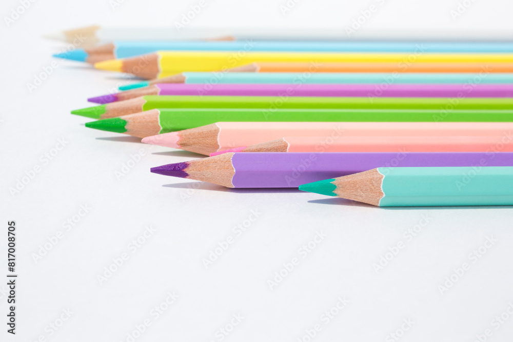Pastel colored pencils in uneven row on a white background Pastel colored pencils in uneven row on a white background