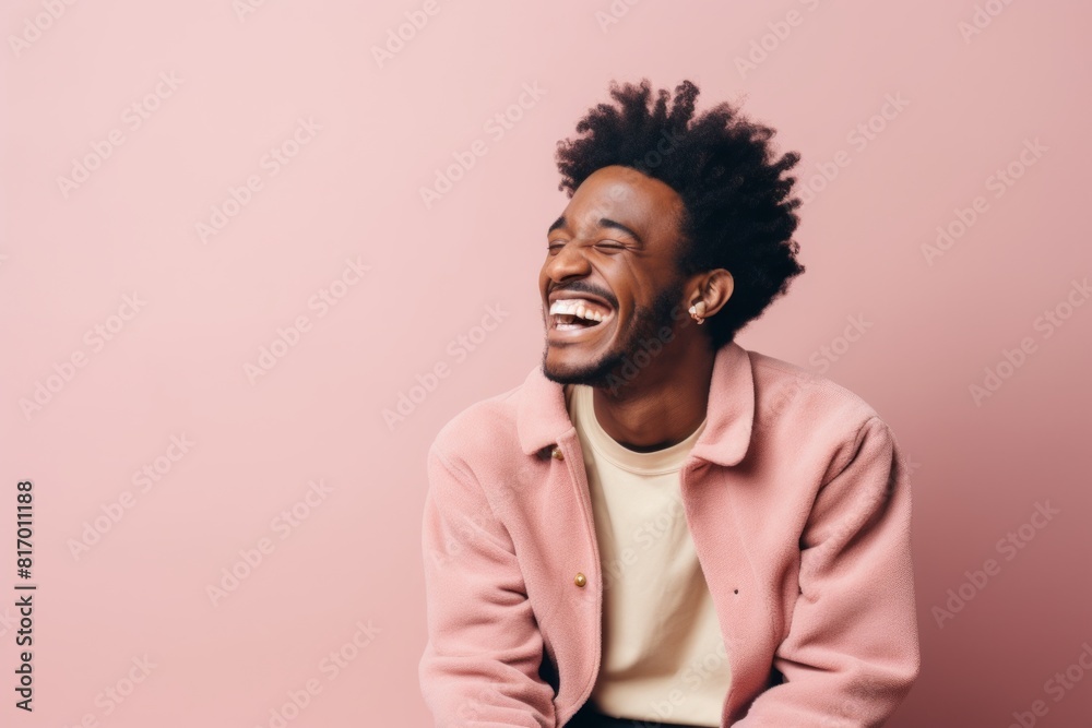 Portrait of a content afro-american man in his 20s laughing isolated in pastel or soft colors background Portrait of a content afro-american man in his 20s laughing isolated in pastel or soft colors background