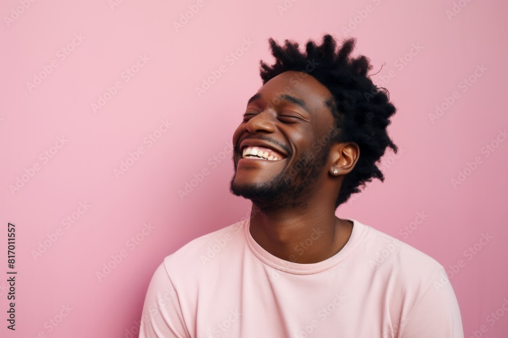 Fototapeta premium Portrait of a tender man in his 20s laughing while standing against pastel or soft colors background