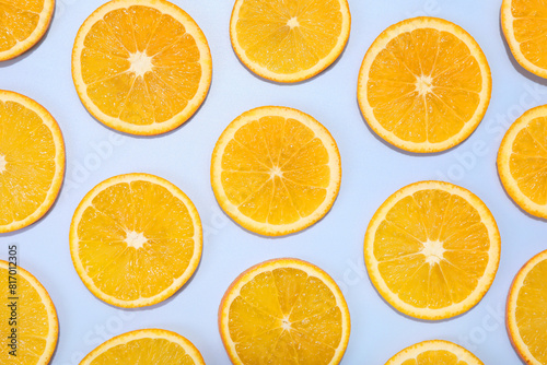 Slices of juicy orange on light blue background, flat lay