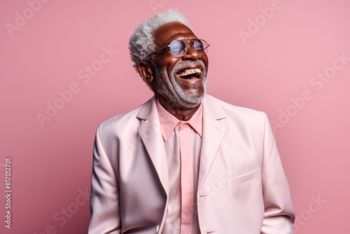 Portrait of a joyful afro-american elderly 100 years old man laughing in front of pastel or soft colors background