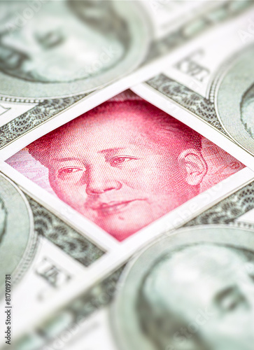 yuan banknote, surrounded by 100 dollar bills. American market protectionism concept, USA vs China conflict in the economy