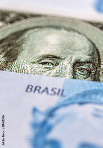 one hundred reais notes and one hundred dollar bills, concept of the Brazilian and United States economy, rising dollar