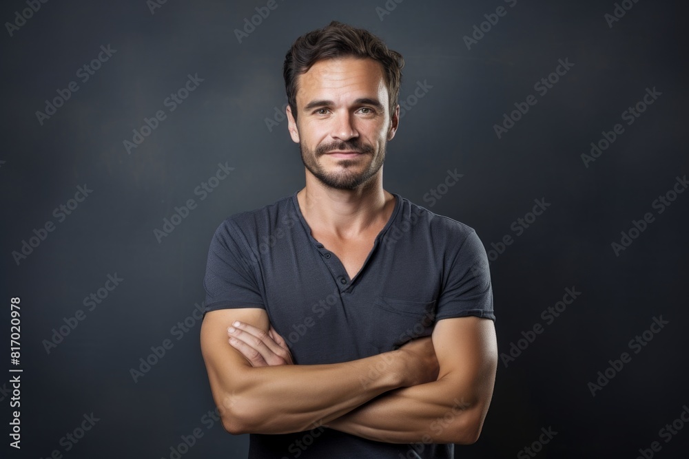 Portrait of a glad man in his 30s with arms crossed in minimalist or empty room background Portrait of a glad man in his 30s with arms crossed in minimalist or empty room background