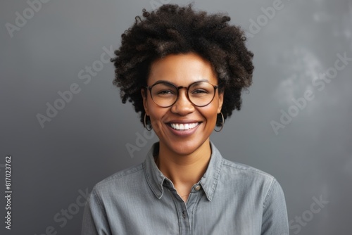 Portrait of a satisfied afro-american woman in her 40s smiling at the camera in front of minimalist or empty room background