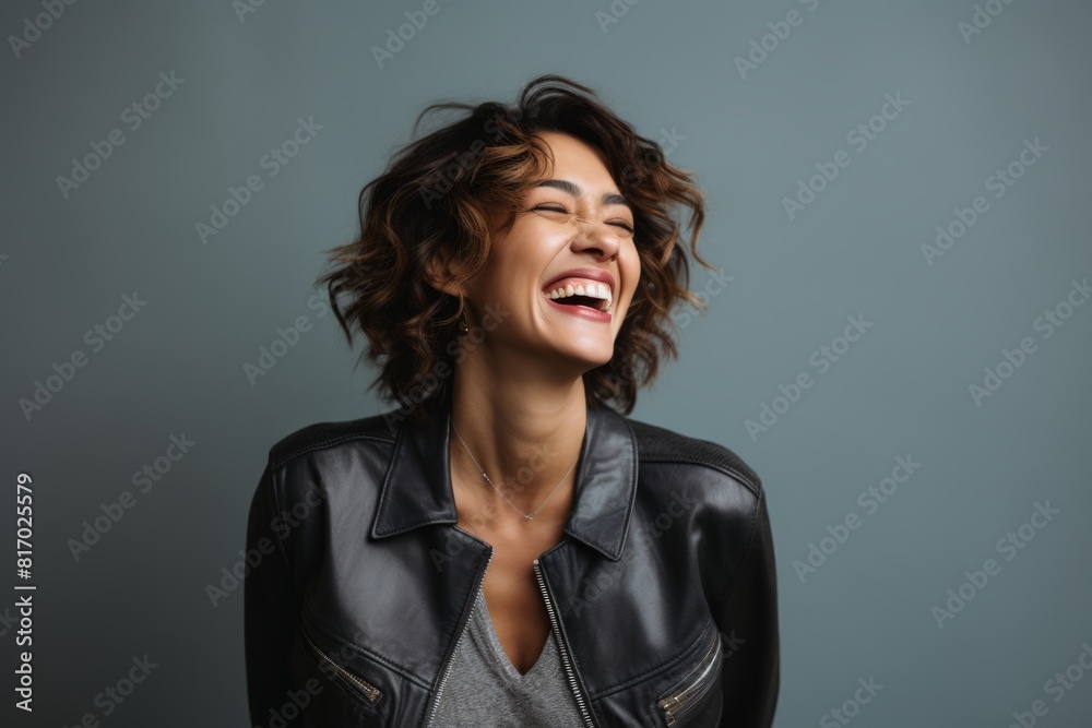 Portrait of a grinning woman in her 40s laughing isolated on minimalist or empty room background Portrait of a grinning woman in her 40s laughing isolated on minimalist or empty room background