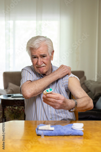 Elderly man monitoring blood sugar levels at home