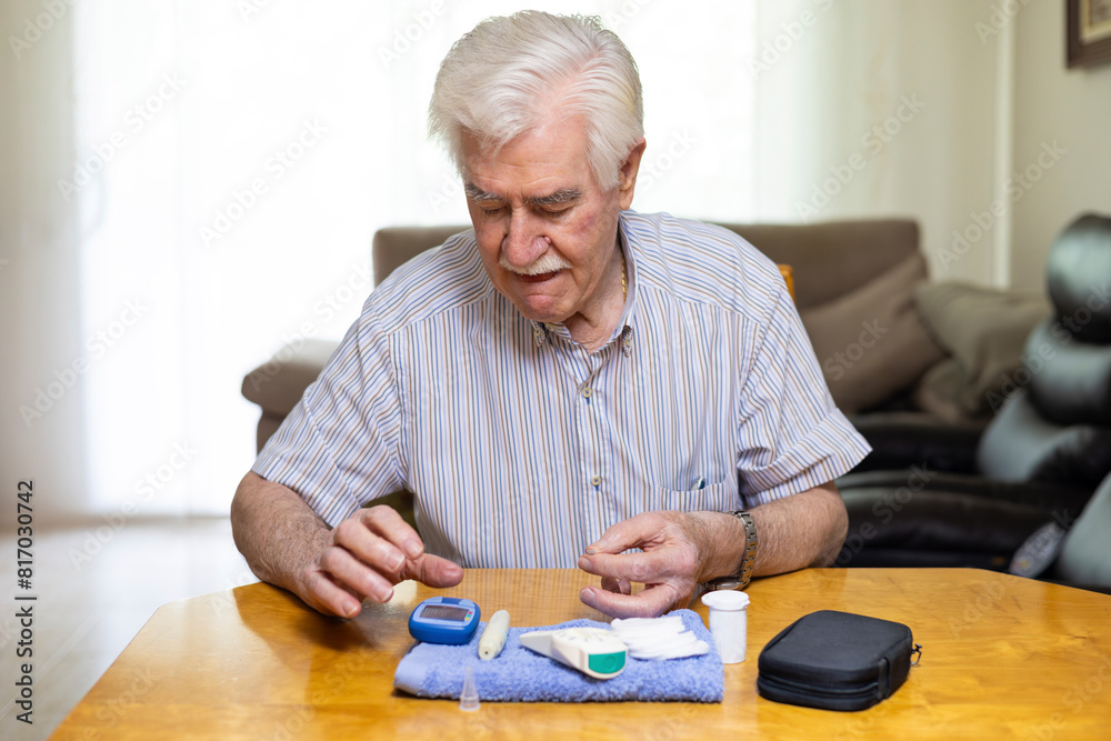 Elderly man monitoring blood sugar levels at home Elderly man monitoring blood sugar levels at home