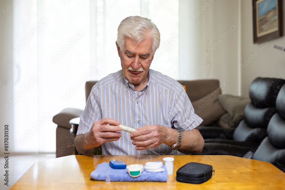 Senior man checking blood sugar level at home Senior man checking blood sugar level at home