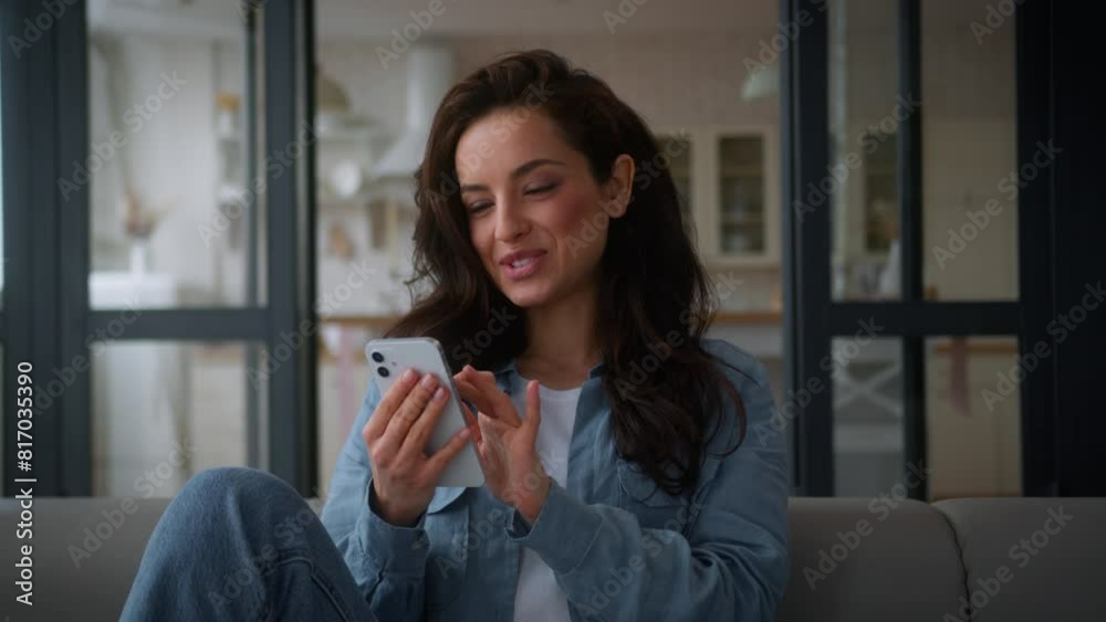 Happy smiling Caucasian woman female girl influencer user smile browsing mobile phone smartphone app chatting social media using cellphone relax at home couch sofa order food delivery shopping online