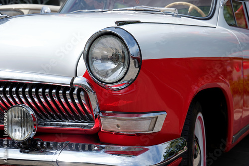 Close-up of the front of a beautiful red and white car. © SKfoto