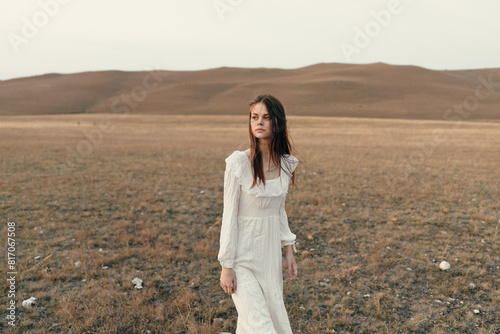 Woman in white dress standing in open field in the desert, embracing freedom and solitude © SHOTPRIME STUDIO