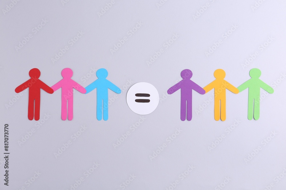 Paper human figures and equals sign on light background, flat lay Paper human figures and equals sign on light background, flat lay