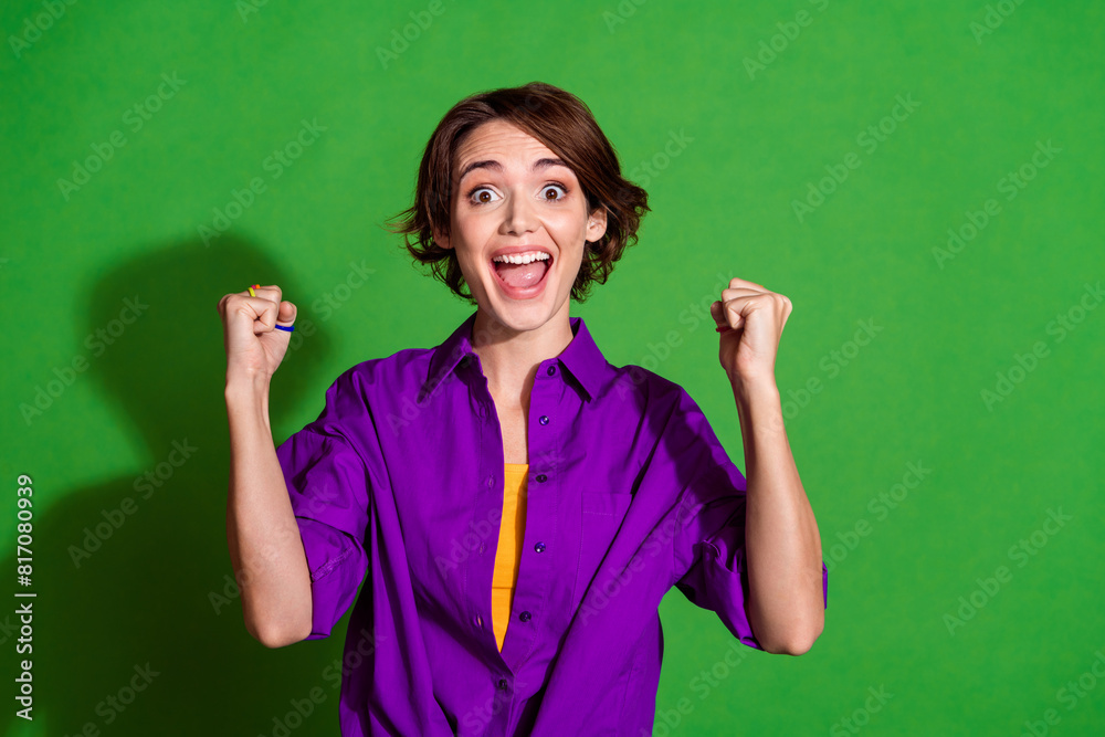 Photo of funny young woman in purple stylish shirt and brown bob haircut celebrate her promotion at job isolated on green color background