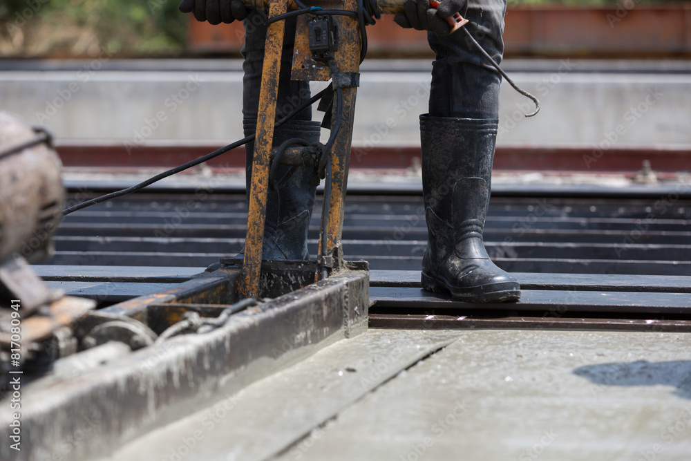 Valokuvatapetti Construction worker operating machine spreading wet concrete pouring at precast concrete wall construction site