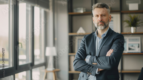 Mature businessman exuding confidence with a thoughtful demeanor in a bright office.