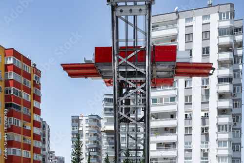 Transporting household goods by elevator to high-rise buildings by mobile vehicle. Carrying furniture up and down lift. Cargo, moving, changing house, moving goods, lift carrying idea.