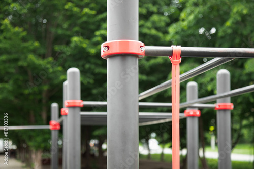 Fitness rubber band for exercise tied on a horizontal bar . Outdoor gym concept . Close up view